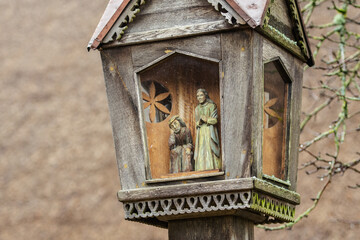 Traditional votive wooden little chapel with figures of Christ and the Madonna in a village in Lithuania