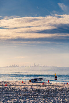 Surf Life Saving board on beach with city in background