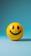 Fototapeta premium A vibrant yellow smiley ball against a serene blue background.