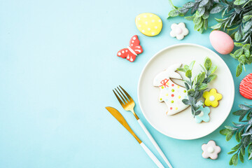 Easter table setting, Easter food background. White plate with eggs and holiday decorations. Top view with copy space.