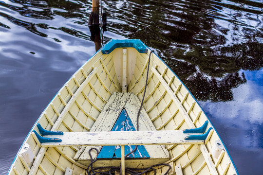 The bow of an old wooden boat, moored.