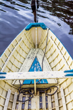 The bow of a wooden boat on the water.