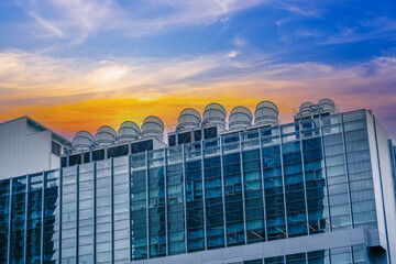 The air conditioning and ventilation system of a large industrial building, evening sunset sky...