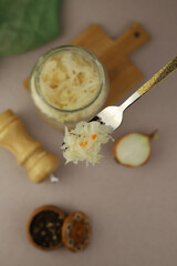 healthy sauerkraut in a transparent jar on a light background