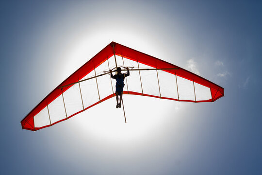 Hang glider soaring in front of the sun.