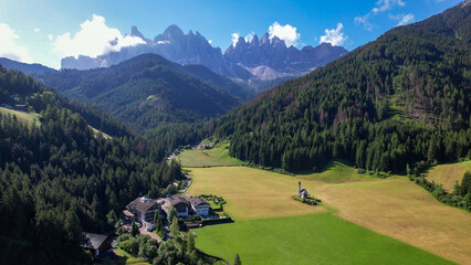 The Odle  Group mountain peaks and the Church of St. John in the Valley of Funes, South Tyrol in northern Italy. The small church of Ranui, is a symbol of South Tyrol's beauty.