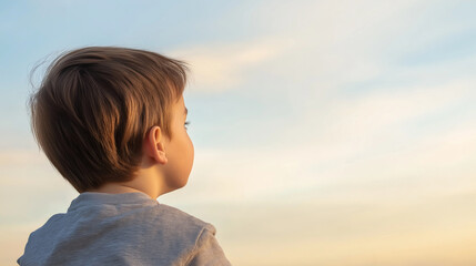 Obraz premium Contemplative child watching vibrant sunset, embodying innocence, hope, and boundless potential against luminous twilight horizon