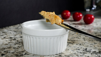 Table knife with hummus on a granite countertop