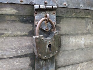 A classic, rusty, heavily worn padlock (horizontal photo)