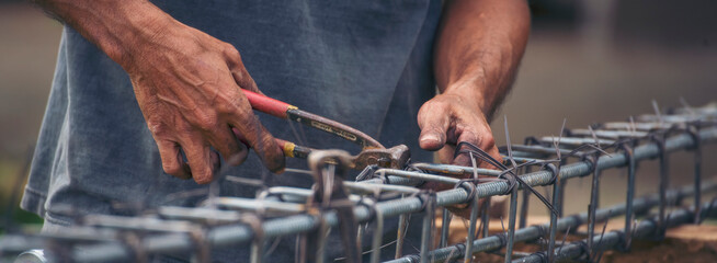Banner Construction Worker hands using pincer pliers iron wire. Outdoor Worker using wire bending pliers. Banner Men hands bending cutting steel wire fences bar concrete worker with copy space