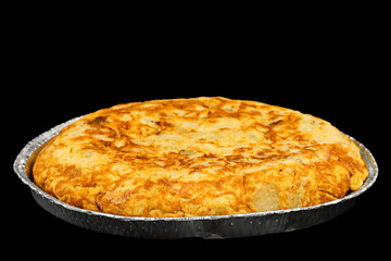 Spanish potato omelette in a foil tray on a black background.