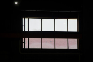 Window span of a production facility in the dark with a view of the street