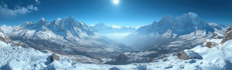Fototapeta premium Snowy mountains with the sun shining brightly over the peaks, casting warm light on the snowy landscape, clear blue skies creating a serene and majestic atmosphere, concept of winter, adventure, natur