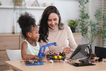 tutor providing a student in STEM lesson in class,a female teacher using tablet computer teach kid...