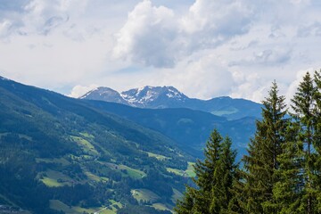 Mountain landscape of Austria. Beautiful view of mountains and meadows with lush green grass.