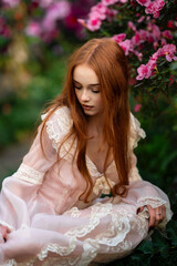 Beautiful red head girl in pink  vintage dress  standing near pink flowers.. Art work of romantic...