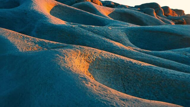 Golden sunlight highlighting sculpted sandstone contours, creating dramatic shadows