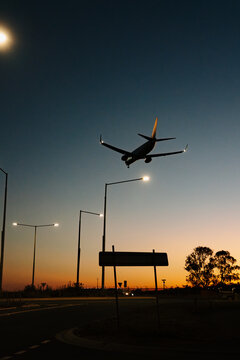 Silhouette of commercial airplane flying in the sky at sunset