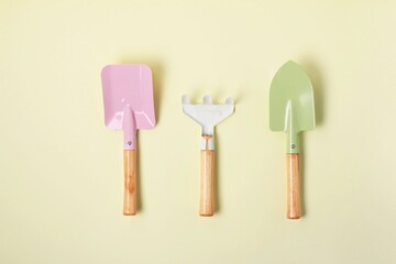 Gardening tools arranged neatly on a pastel yellow background for home gardening enthusiasts
