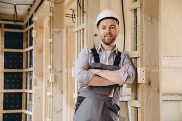 Construction worker smiling with crossed arms in modular building