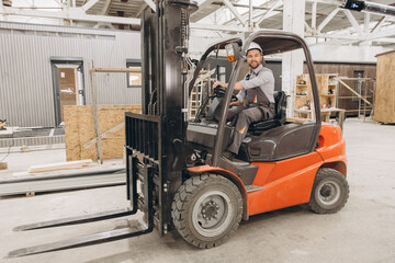 Engineer driving forklift in modular building factory