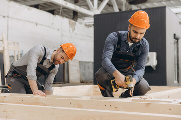 Construction workers building wooden frame for modular building