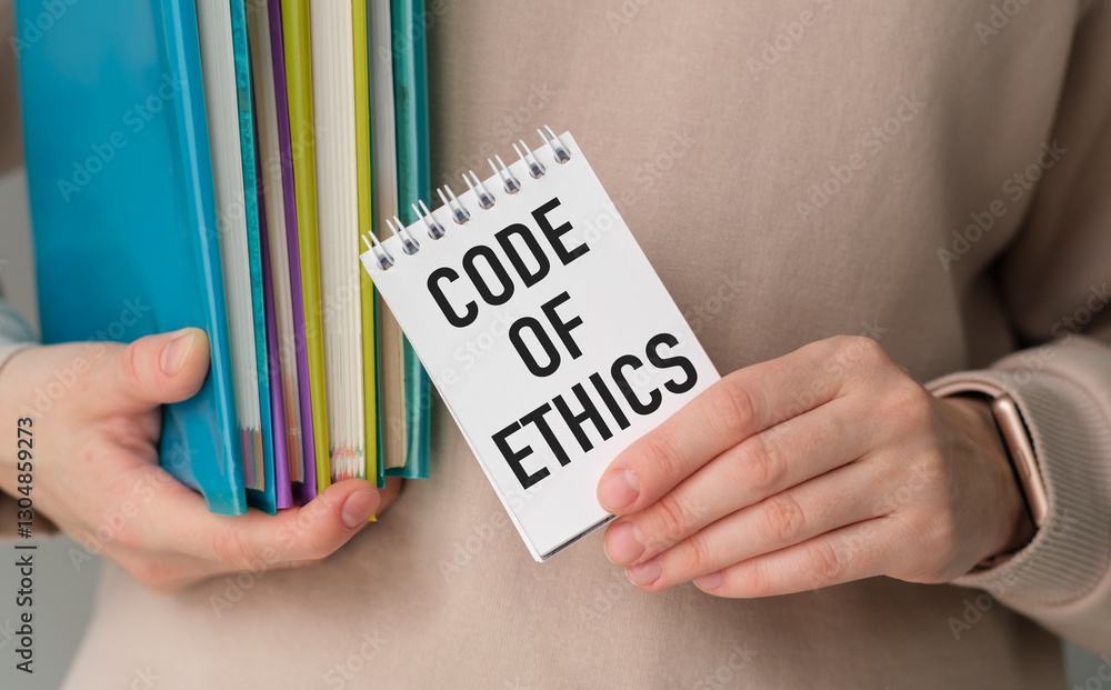 Poster a person is holding a stack of books and a spiral bound notebook with the word code of ethics writte