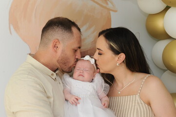 pai e mãe com bebe fofo no batizado 