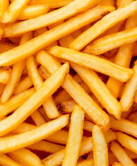 Crispy golden French fries piled together, creating delicious and tempting texture. Perfect for snacking or as side dish, these fries are favorite comfort food