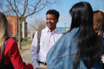 Happy african american university student chatting with his colleagues on campus