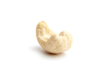Close-up of a single raw cashew nut showcasing its curved shape, smooth texture, and natural cream color. Ideal for healthy eating and snack visuals
