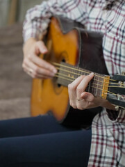 Close-up of female hands skillfully playing an acoustic guitar, practicing intricate chords and...