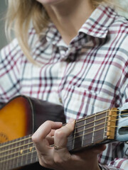 Capturing the intricate details of a musician's hands skillfully playing chords on an acoustic...