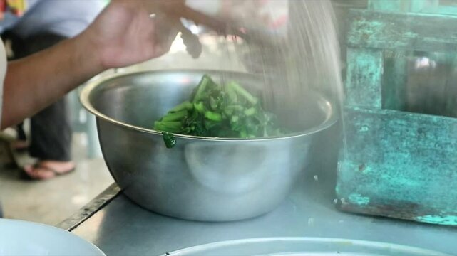 Preparing traditional asian food of chicken noodles for customers. View of a penjual mie ayam bakso or meatball chicken noodle.Focus on food.blurred,shake video,exposure