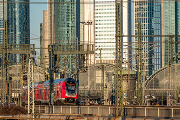 Ein- oder ausfahrender Nahverkehrszug im Hauptbahnhof Frankfurt am Main mit Hochhäusern des Bankenviertels im Hintergrund