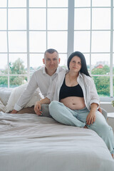 Family pregnancy photoshoot with father, pregnant mother, and son