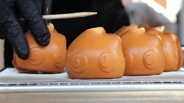 Tokyo street food sweets Ningyo - yaki. Japanese shaped sponge cakes, small baked pastries made in special molds, filled with sweet red bean paste - anko or custard cream.