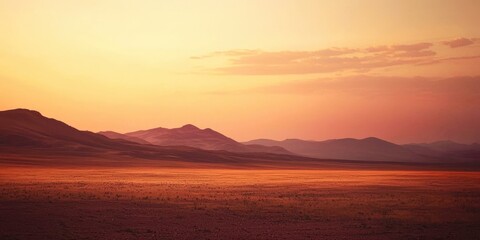 Fototapeta premium Large, empty field with mountains in the background