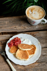 pancakes with cherry sauce. Wooden background, top view