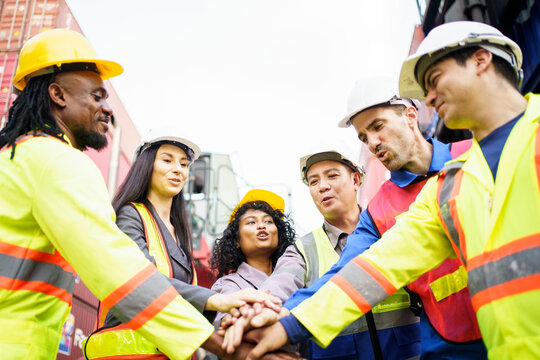 Team of engineers and workers are touching hand together, their face are fully with smile and motivation to success.