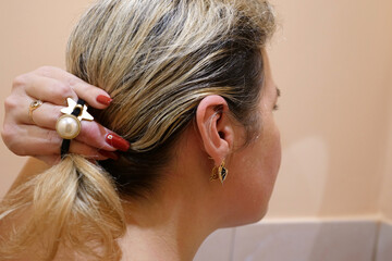 A woman combs her hair in the morning. Hair care.