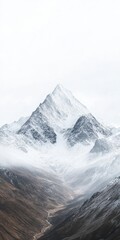 Obraz premium Majestic Snow Covered Mountain Peak in Misty Valley