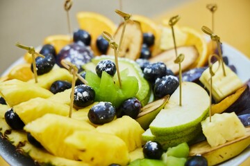 A plate of fruit with a variety of fruits including apples, oranges, and grapes.