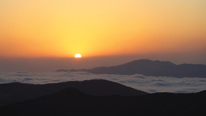 Fototapeta premium Breathtaking Sunrise Over Rolling Mountainous Landscape and Scenic Clouds