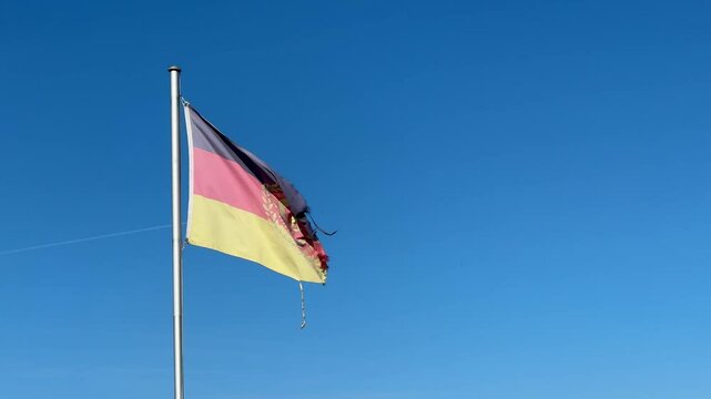 colorful east germany gdr flags on blue sky 4k