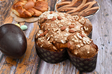 Colomba pasquale or Easter Dove is a traditional Italian dessert prepared with sourdough, almonds and candied fruit top view with chocolate egg pastiera and casatiello napoletano