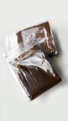 Two transparent ziplock pouches filled with finely ground coffee