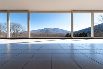 Modern interior with large windows overlooking mountain landscape on a sunny day