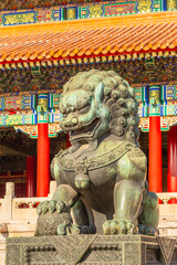 Obraz premium Golden chinese guardian lion or shishi statue from Ming dynasty era, at the entrance to the palace in the Forbidden City, Beijing, China