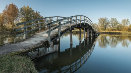Fototapeta premium Scenic Wooden Bridge Over Calm Water Surrounded by Lush Greenery Under Blue Sky